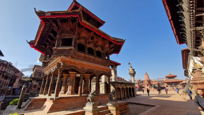       Traditional Nepalese architecture with intricate carvings in a city square.
  