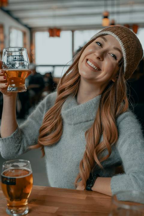 Close-up of a smiling woman holding a drink.
