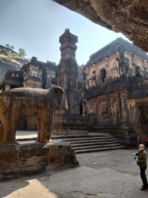 Stone elephant statue with an ancient temple background.