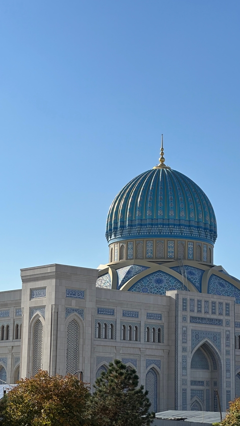 A beautiful blue-tiled dome with intricate patterns under a clear sky.