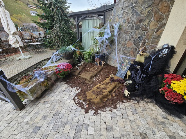       Halloween decoration setup with spider webs and flowers.
  