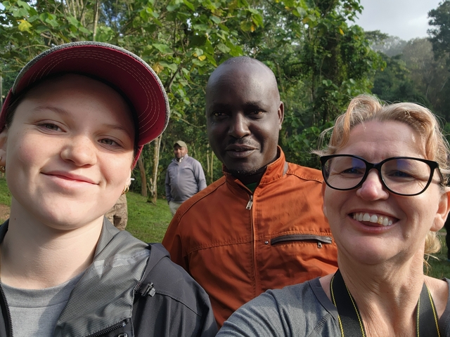       Selfie of three people smiling in a green scenic background.
  