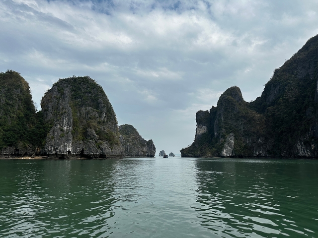 Serene view of limestone formations with a clear sky and calm water.