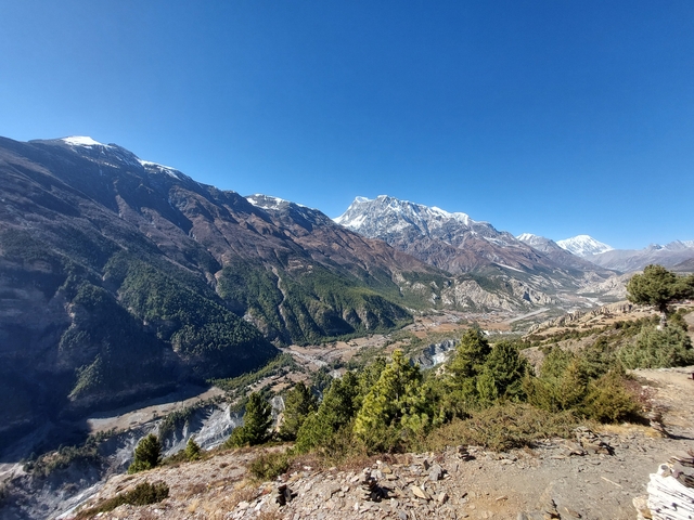 Scenic view of a valley with a river and mountains.