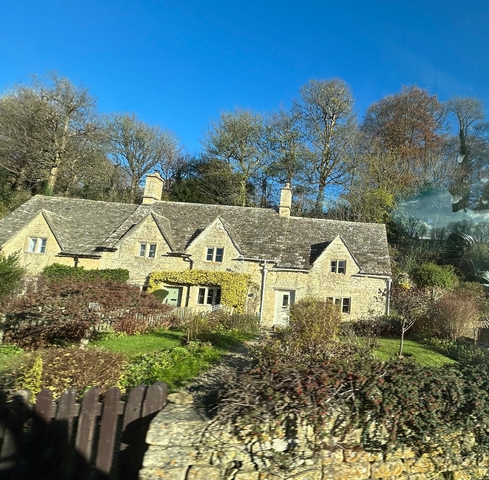       Stone cottage with a garden in a scenic village.
  