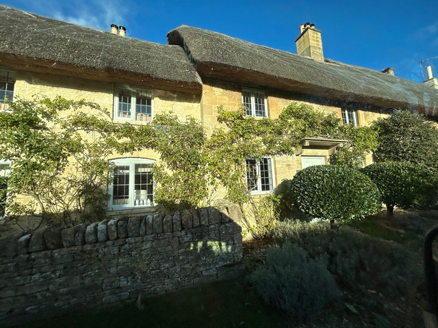       Stone cottage with ivy growing on the facade.
  