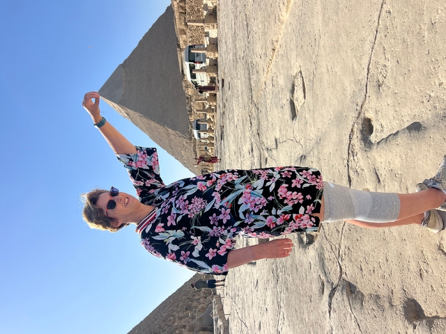       Woman posing holding the tip of a pyramid in perspective.
  