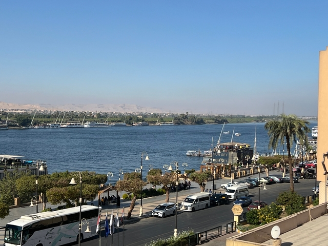 Riverside view with ships and buildings in the background.