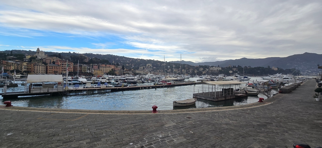 Harbor with boats and hilly landscape in the background.