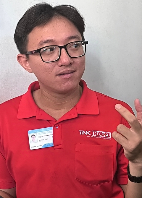 Person wearing a red shirt with a badge.