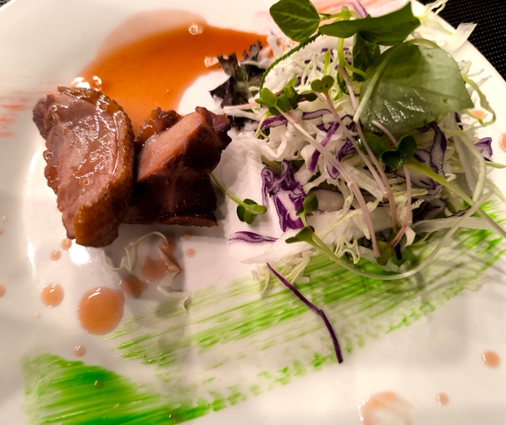 Plate of gourmet food with meat and salad.