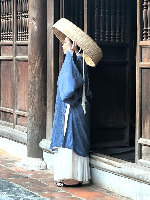 Traditional Vietnamese attire hanging by a wooden door.