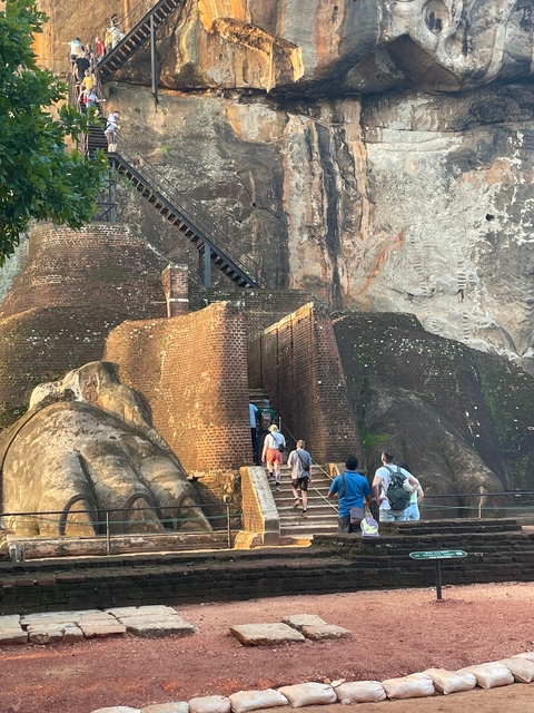       People ascending the ancient rock fortress.
  