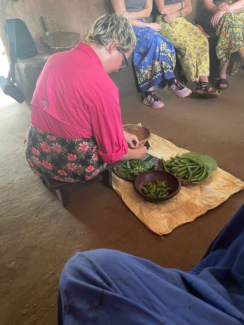 Person preparing local vegetables at a market.