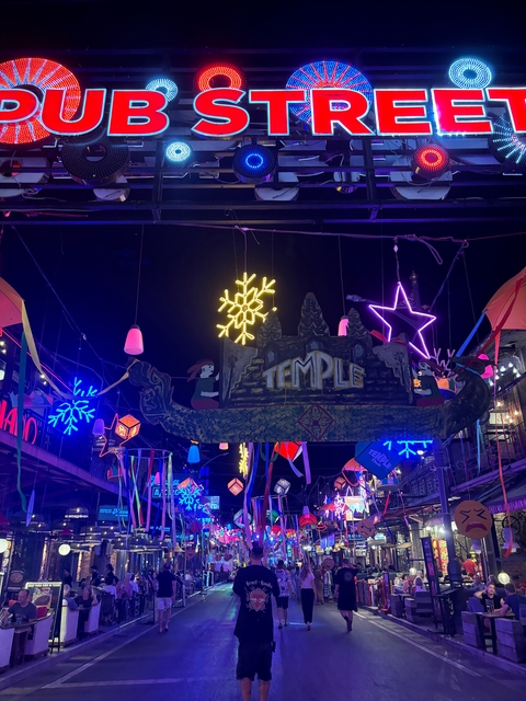       Street decorated with vibrant neon lights and signs at night.
  