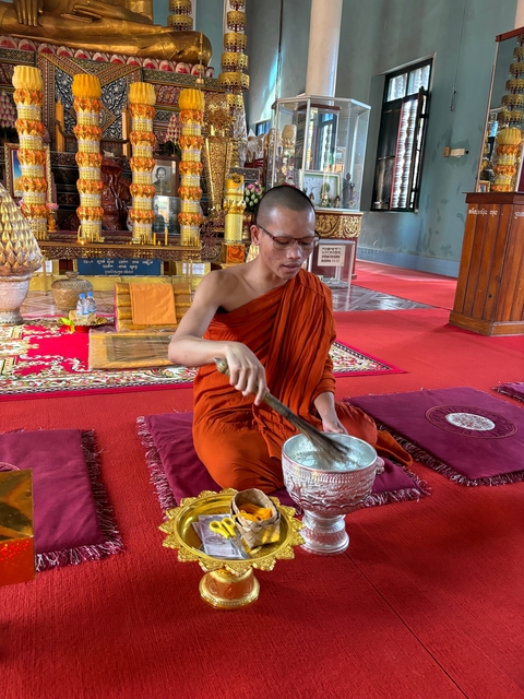       Monk preparing ritual items in a temple.
  