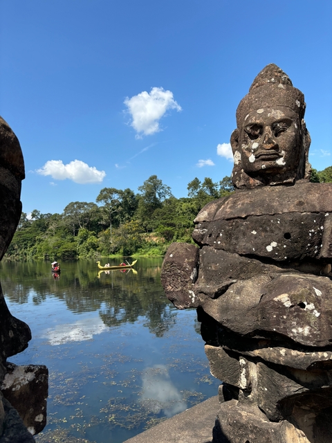       Scenic view of a river and ancient statue with boats in the distance.
  