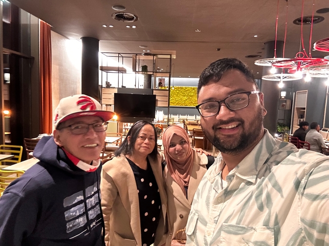 Group of four inside a cafe smiling at the camera.