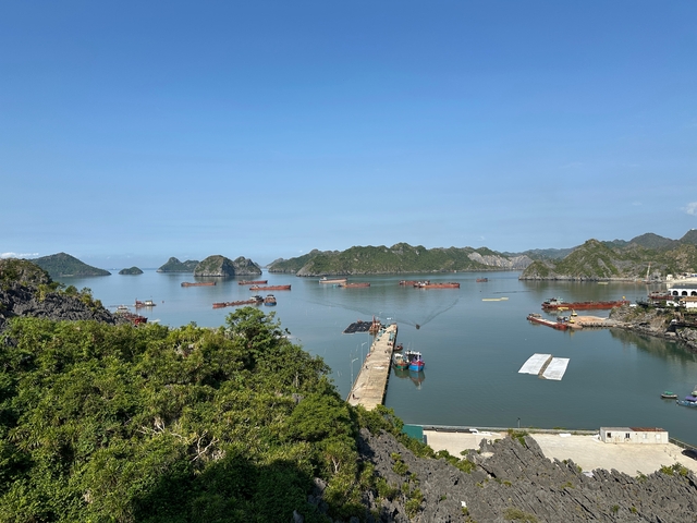 Scenic coastal view with karst formations and boats.
