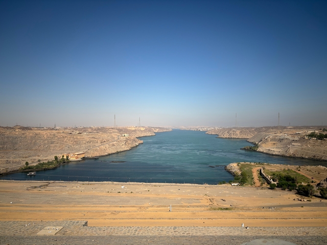 Wide river or lake between desert hills.