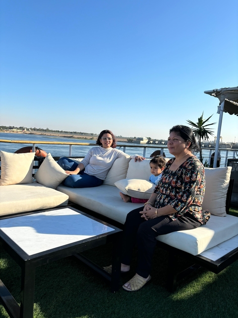 Family relaxing on a boat with a view of a river.