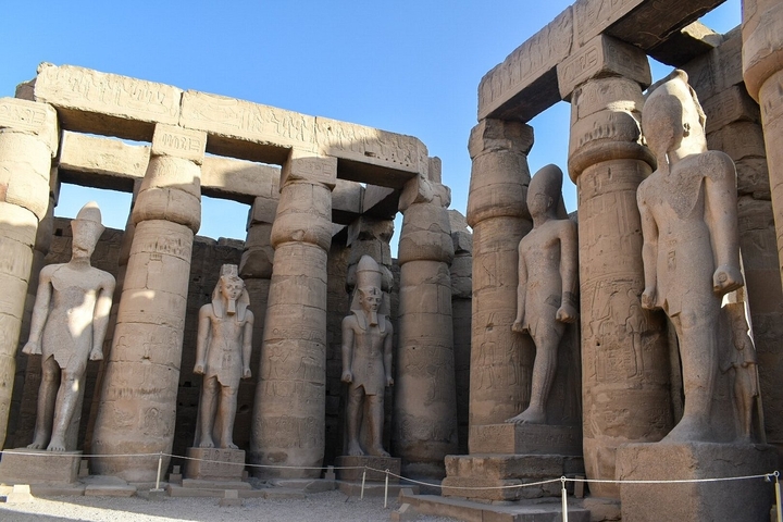 Ancient Egyptian temple with statues and pillars.