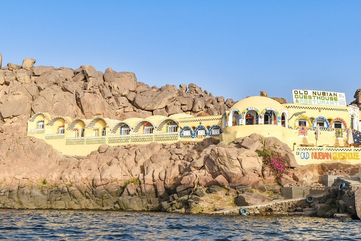 Colorful guesthouse built into a rocky hillside.