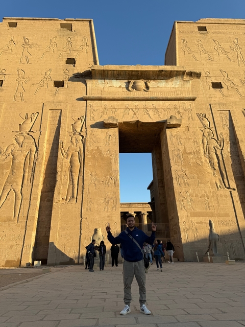 Front view of an ancient temple with carvings and a person.