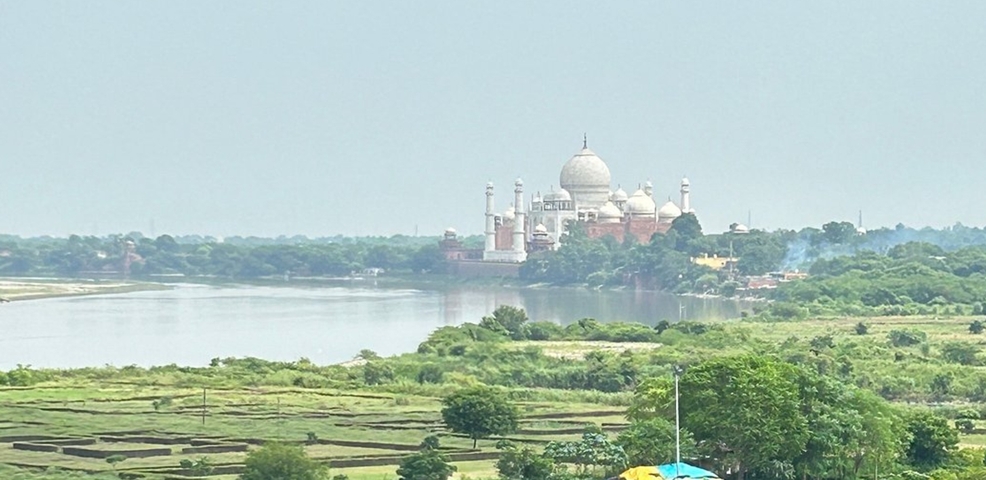 View of the Taj Mahal from a distance across a river.