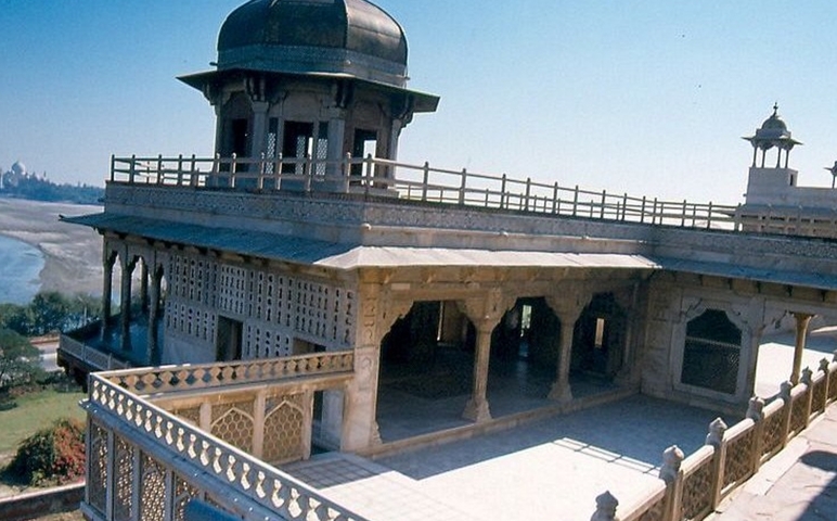       Historic architecture overlooking a river, with distant domes.
  
