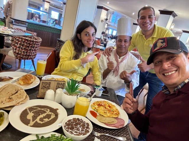 People dining with a chef in a restaurant setting.