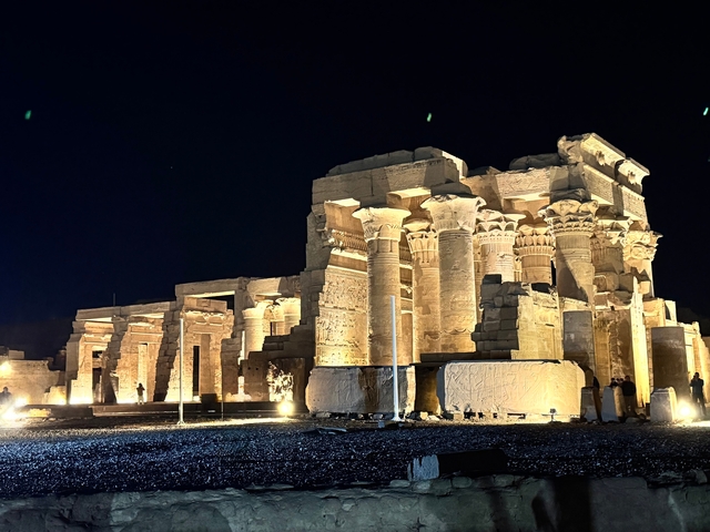 Illuminated columns of an ancient temple at night.