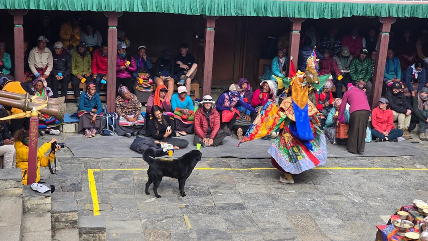      Vibrant traditional performance with onlookers seated around.
  