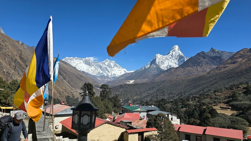      Panoramic view of snow-capped mountains with prayer flags.
  
