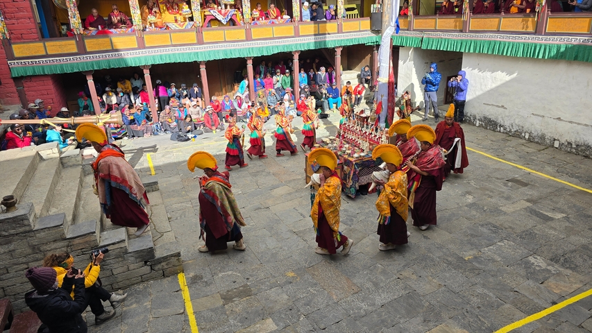 Traditional procession with monks in colorful attire.