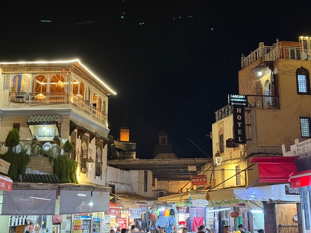       Night scene of a well-lit hotel building.
  