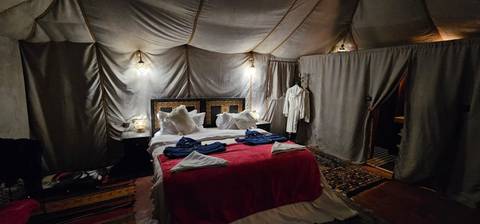       Interior of a luxury tent with a bed.
  