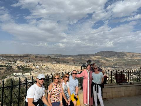       Group of people posing with a view of a city
  