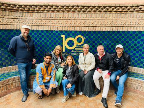       Group of people posing in front of a tiled wall.
  