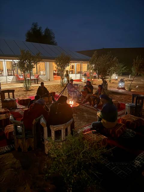       Group gathered around a campfire at night.
  