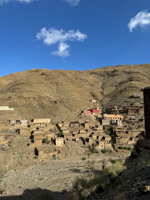       Village on a hillside with a blue sky.
  