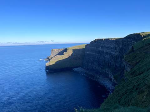Steep cliffs with clear sky and blue sea.