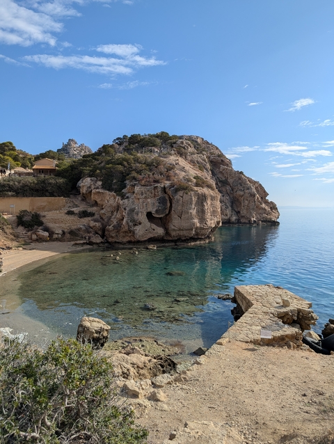 A cove with rocky cliffs and clear water.