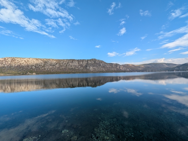 A large lake reflecting the sky and distant hills.