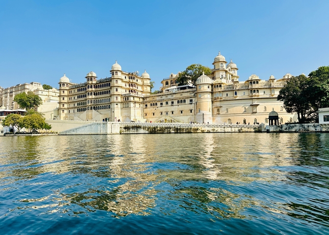 Palace complex by the lake with reflection on water.