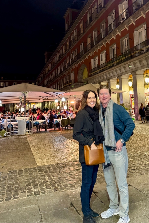 Couple enjoying an outdoor evening meal at a plaza.