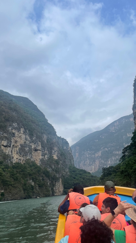       Steep canyon cliffs under a cloudy sky.
  