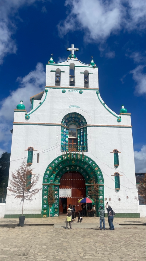       A colorful church with green decorative elements.
  