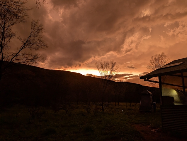       Sunset view with dramatic clouds and a silhouette of a cabin.
  