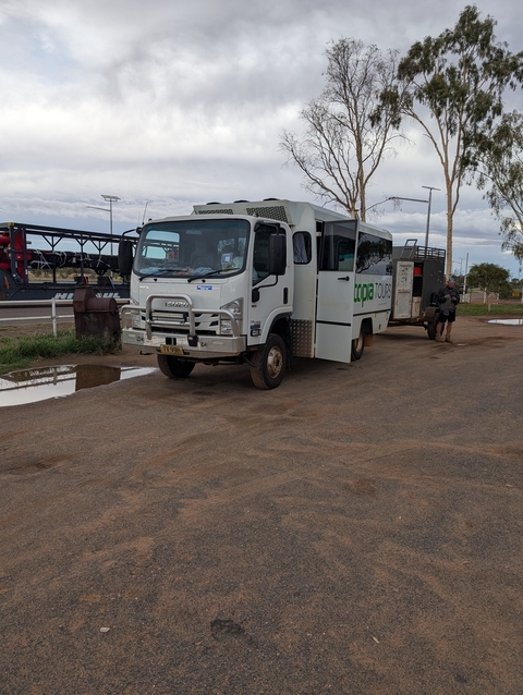 Parked tour vehicle on a dirt road.